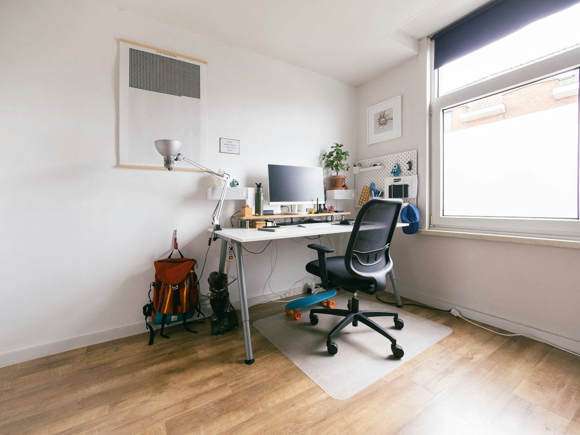 black office rolling chair beside white wooden desk